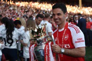 Arteta segurando taça da Premier League de 2025/26, conquistada pelo Arsenal