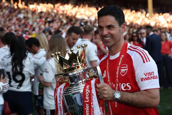 Arteta segurando taça da Premier League de 2025/26, conquistada pelo Arsenal